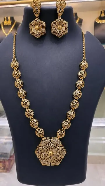 Antique gold-tone necklace set on a display bust